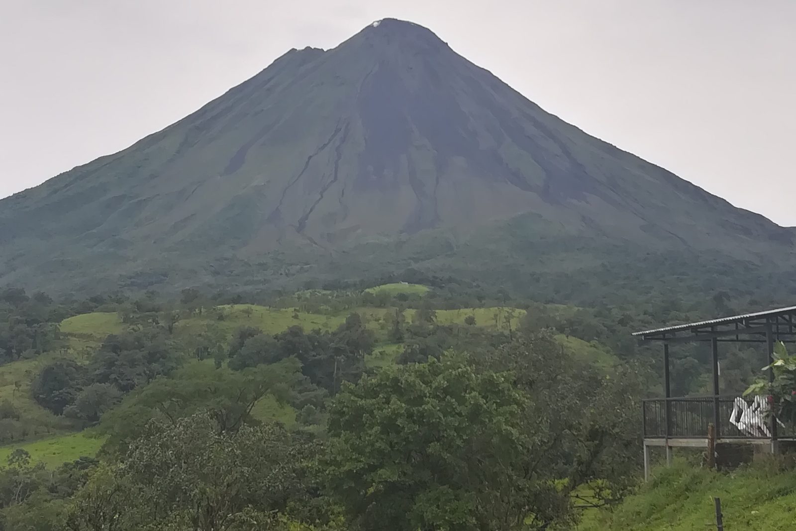 Arenal Volcano rising above green farmland, Costa Rica